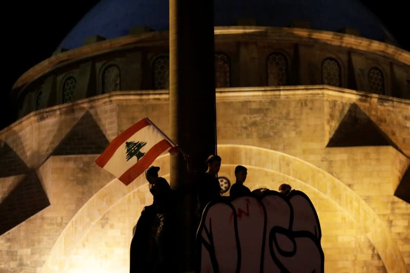 Protesters stand on the top of a structure at a demonstration during ongoing anti-government protests in Beirut