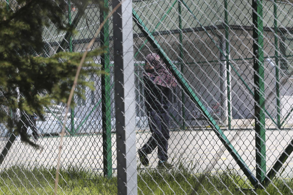 A girl walks inside a detention center where authorities brought back from Syria 110 Kosovar citizens, mostly women and children in the village of Vranidol on Sunday, April 20, 2019. Four suspected fighters have been arrested, but other returnees will be cared for, before being sent to homes over the coming days according to Justice Minister Abelard Tahiri. (AP Photo/Visar Kryeziu)