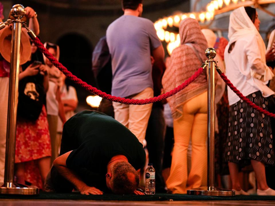 A worshipper prays as tourists visit the Byzantine-era Hagia Sophia mosque in Istanbul on July 4, 2023.