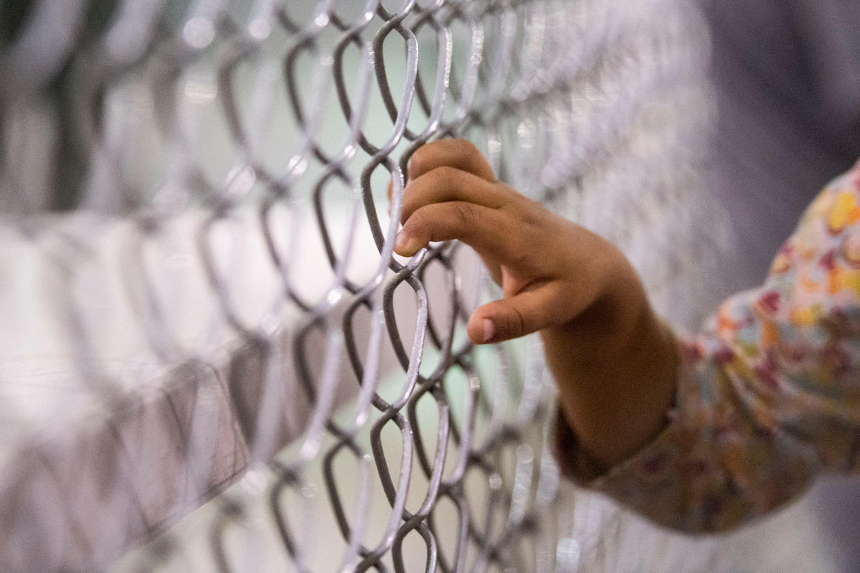 A child holds onto a fence in the U.S. Border Patrol Central Processing Center in McAllen, Texas, on Aug. 12, 2019.