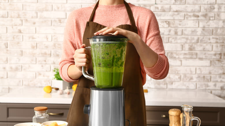 woman blending green sauce