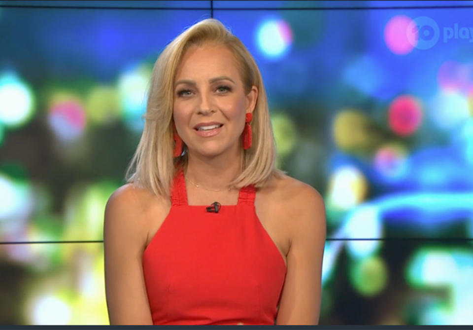 Carrie Bickmore wearing a red halterneck top on The Project