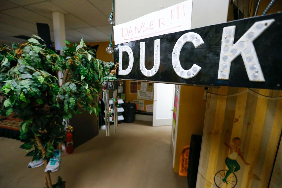 A sign warning venue attendees to 'duck' hangs on a ventilation unit at The Shoe Tree Listening Room on East St. Louis Street on Thursday, Feb. 8, 2024.