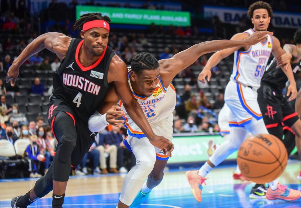 Rockets forward Danuel House Jr. (4) tries to beat Thunder guard Shai Gilgeous-Alexander (2) to the ball during the first half.