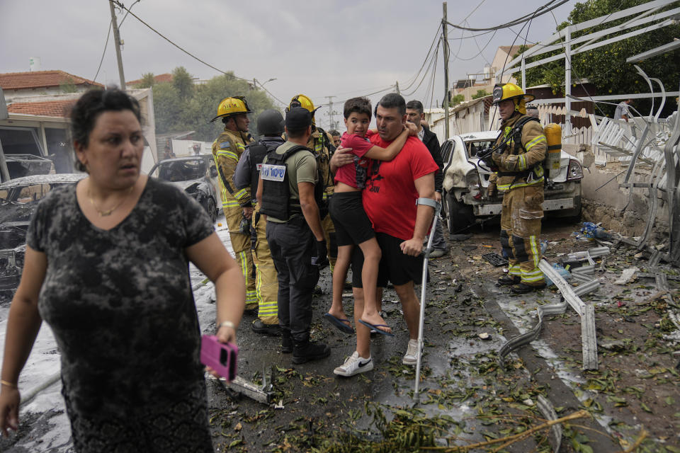 Israelíes evacuan un lugar alcanzado por proyectil lanzado desde la Franja de Gaza, en Ashkelon, en el sur de Israel, el 9 de octubre de 2023. (AP Foto/Ohad Zwigenberg)