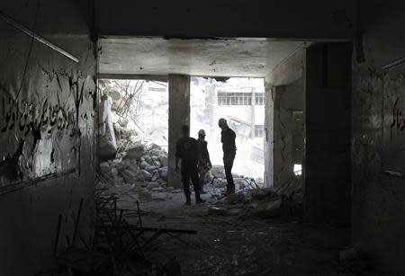 Rescuers watch an excavator operating at Ain Jalout school that was hit by what activists said was an airstrike by forces loyal to Syria's President Bashar al-Assad in Aleppo's al-Ansari al-Sharqi neighbourhood April 30, 2014. REUTERS/Jalal Al-Mamo