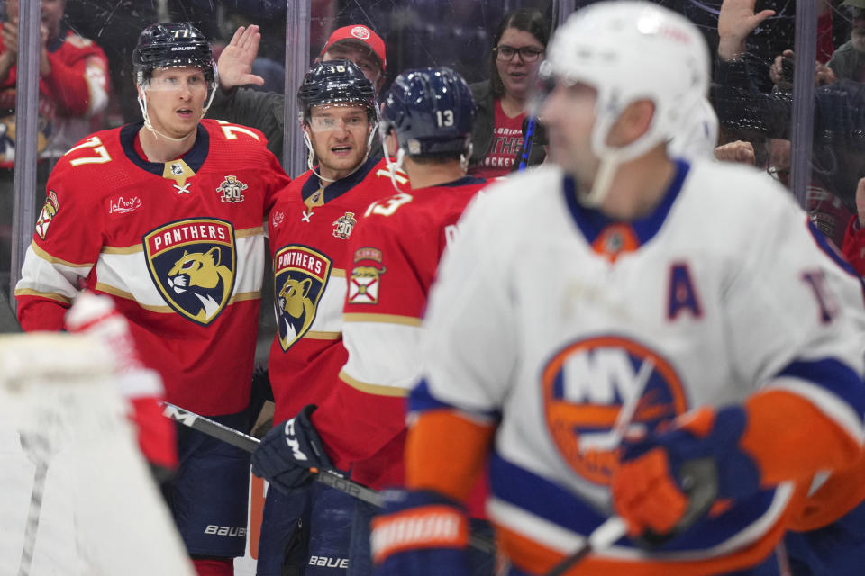 Florida Panthers center Aleksander Barkov (16) celebrates a goal against the New York Islanders with defenseman Niko Mikkola (77) and center Sam Reinhart (13) during the second period of an NHL hockey game Thursday, March 28, 2024, in Sunrise, Fla. (AP Photo/Jim Rassol)