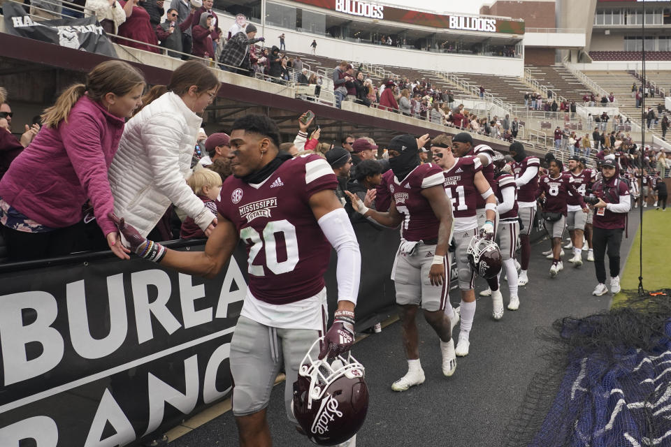 Mississippi State Gridiron Club members and their guests congratulate players following the team's win in an NCAA college football game against East Tennessee State, Saturday, Nov. 19, 2022, in Starkville, Miss. The end zones are not necessarily where you will find the cheap seats anymore at college football games. Several colleges have tried making end-zone seating more attractive by turning it into a premium experience that includes such amenities as access to indoor clubs with expanded food and beverage options. (AP Photo/Rogelio V. Solis)