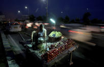 In this Thursday, Sept. 5, 2019, photo, a roadside fruit seller waits for customers as vehicles drive past in Noida on the outskirts of New Delhi, India. Confidence in the Indian economy is giving way to uncertainty as growth in the labor-intensive manufacturing sector has come to a near standstill, braking to 0.6% in the last quarter from 12.1% in the same period a year earlier. (AP Photo/Altaf Qadri)