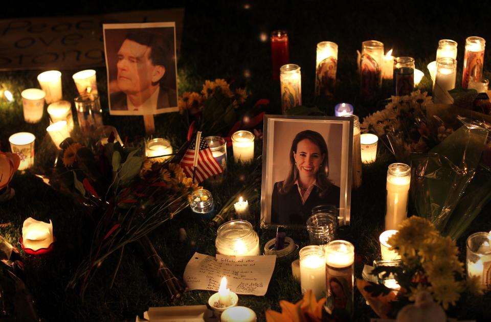 Candles surround portraits of federal judge John Roll and U.S. Rep. Gabrielle Giffords at a memorial following the Jan. 8, 2011, mass shooting.