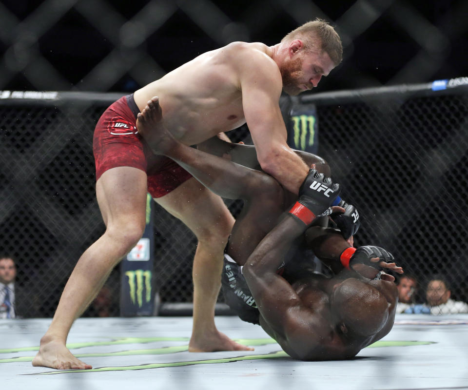 FILE - In this Dec. 16, 2017, file photo, Jan Blachowicz, top, battles Jared Cannonier during a light heavyweight mixed martial arts bout at UFC Fight Night in Winnipeg, Manitoba. Błachowicz faces Glover Teixeira for the light heavyweight title on Saturday, Oct. 30, 2021, in Abu Dhabi, United Arab Emirates. (John Woods/The Canadian Press via AP, File)