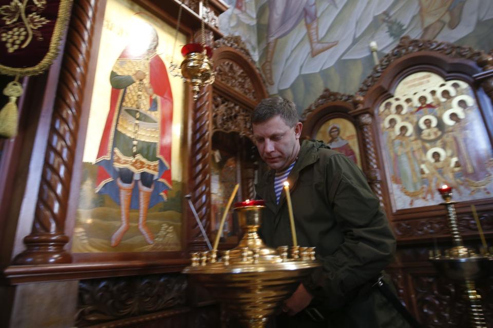 Alexander Zakharchenko, separatist leader of the self-proclaimed Donetsk People's Republic, lights a candle at the temple of Archangel Michael during his visit to Makeevskiy coking plant in Makiivka, outside Donetsk, October 29, 2014. Ukraine on Tuesday condemned as "destructive and provocative" Russia's stance towards elections organised by pro-Russian separatists in eastern Ukraine next Sunday, saying Moscow's recognition of the vote could wreck chances of bringing peace. REUTERS/Maxim Zmeyev (RUSSIA - Tags: POLITICS CIVIL UNREST ELECTIONS)