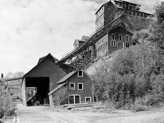 black and white photo of the Kennecott Mining Corporation with buildings built on the side of a cliff