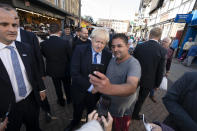 Britain's Prime Minister Boris Johnson poses for a selfie with a member of the public during a visit to Doncaster Market, in Doncaster, Northern England, Friday Sept. 13, 2019. Johnson will meet with European Commission president Jean-Claude Juncker for Brexit talks Monday in Luxembourg. The Brexit negotiations have produced few signs of progress as the Oct. 31 deadline for Britain’s departure from the European Union bloc nears. ( AP Photo/Jon Super)