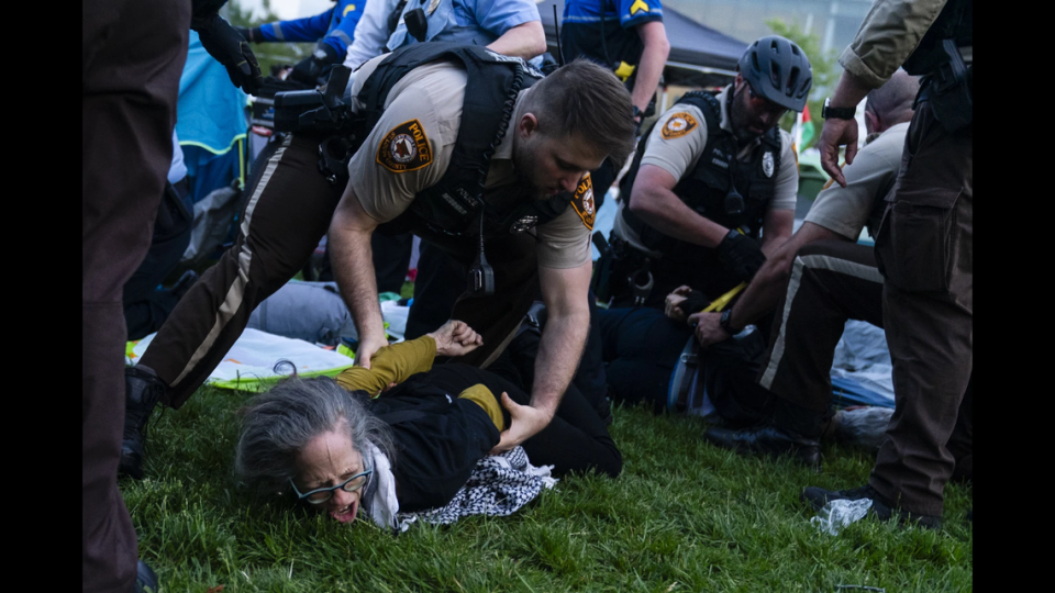A St. Louis County police officer arrests a demonstrator on Saturday at Washington University. Protesters marched through campus and set up an encampment in response to the university’s ties to Boeing, which supplies weapons to Israel.
