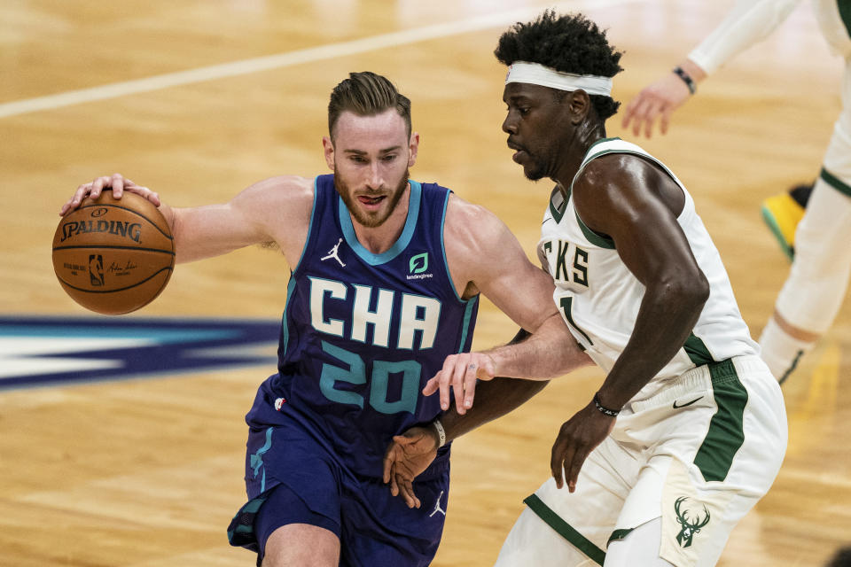 Charlotte Hornets forward Gordon Hayward (20) is guarded by Milwaukee Bucks guard Jrue Holiday during the first half of an NBA basketball game in Charlotte, N.C., Saturday, Jan. 30, 2021. (AP Photo/Jacob Kupferman)