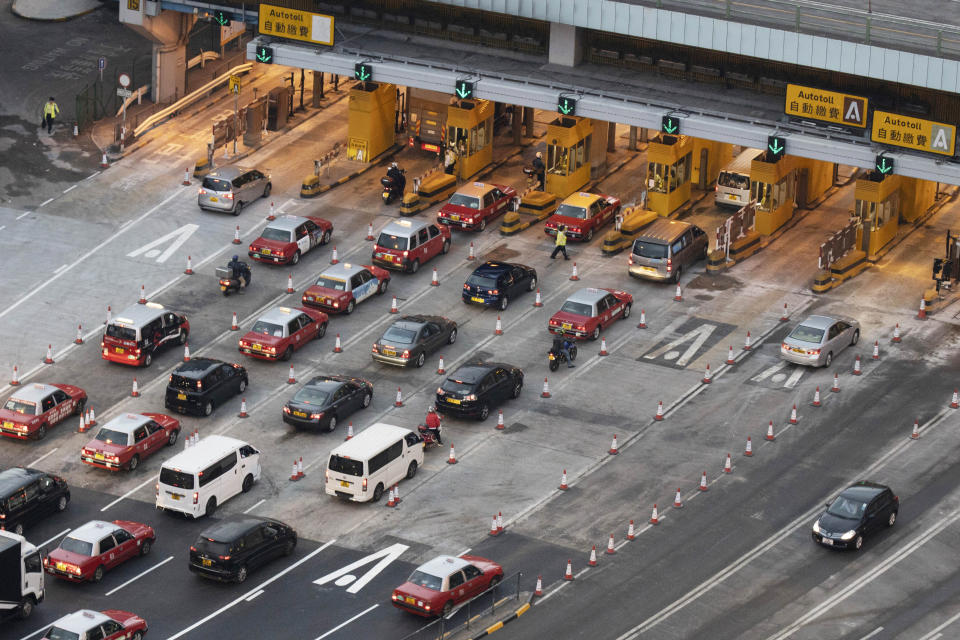 Vehicles queue up at the toll booths to enter the Cross-Harbor Tunnel, which has reopened, in Hong Kong on Wednesday, Nov. 27, 2019. Closed by protesters who took over the neighboring Hong Kong Polytechnic University, the tunnel has reopened after authorities repaired the damages caused. (AP Photo/Ng Han Guan)