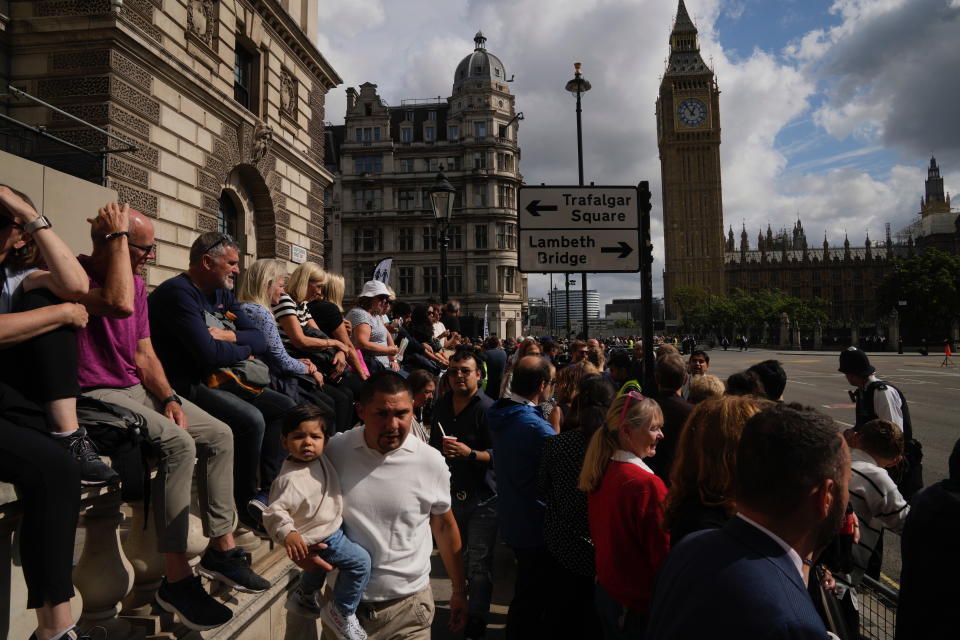 People gather along for the procession of the coffin of Queen Elizabeth II from Buckingham Palace to Westminster Hall, in London, Wednesday Sept. 14, 2022. Queen Elizabeth II, Britain's longest-reigning monarch and a rock of stability across much of a turbulent century, died Thursday Sept. 8, 2022, after 70 years on the throne. She was 96. (AP Photo/Kin Cheung)