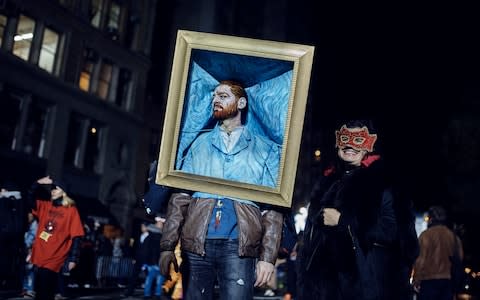 A reveler poses for the photographers during the Greenwich Village Halloween Parade - Credit: AP