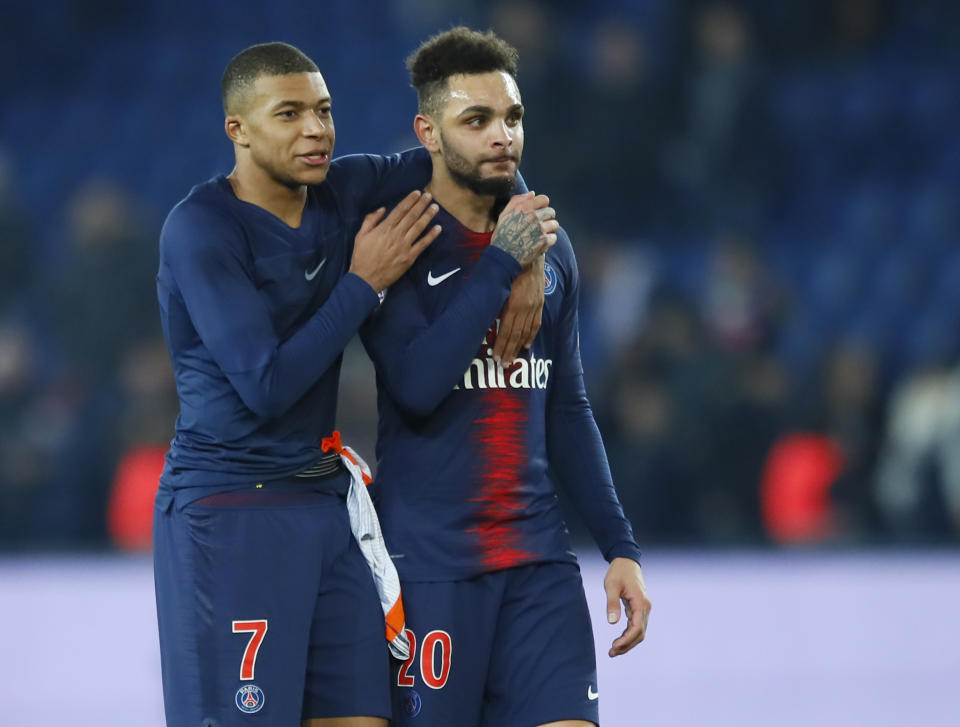 PSG's Kylian Mbappe, left, and PSG's Layvin Kurzawa walk on the pitch at the end of the French League One soccer match between Paris Saint Germain and Montpellier at the Parc des Princes stadium in Paris, France, Wednesday, Feb. 20, 2019. (AP Photo/Francois Mori)