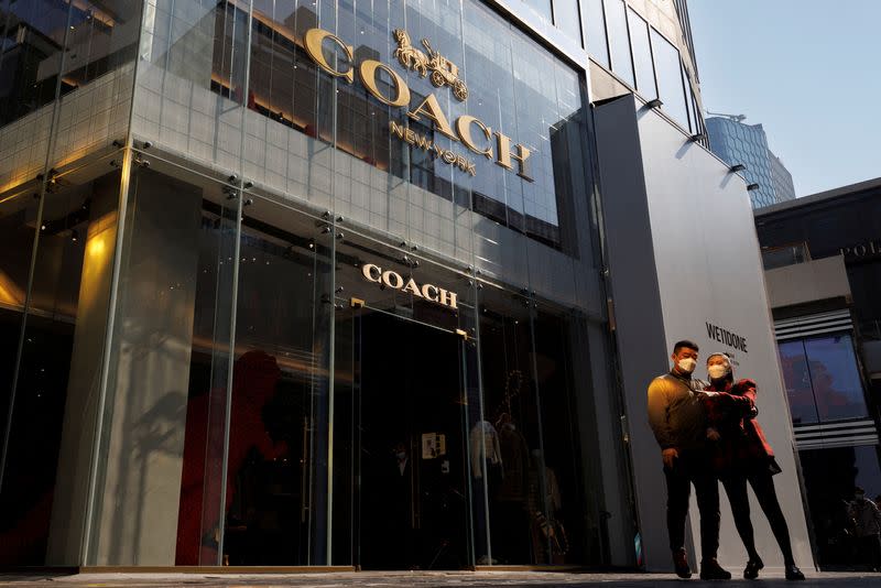 FILE PHOTO: People walk past a store of the Coach luxury fashion retailer in a shopping district in Beijing