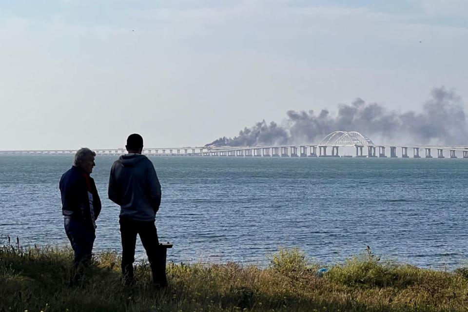 <div class="inline-image__caption"><p>People look at thick black smoke rising from a fire on the Kerch bridge that links Crimea to Russia, after a truck exploded near Kerch on Oct. 8, 2022.</p></div> <div class="inline-image__credit">Roman Dmitriyev/AFP via Getty</div>