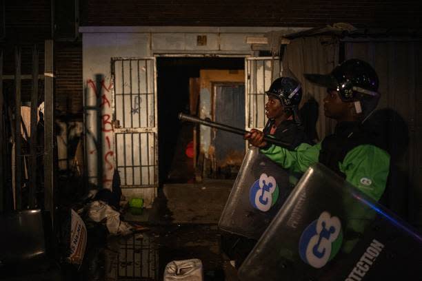 Private security guards patrol the scene of a fire in Johannesburg on 31 August 2023 (AFP via Getty Images)