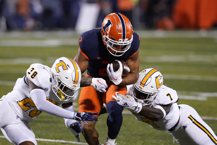 Illinois running back Chase Brown is tackled by Chattanooga defensive backs Jordan Walker, left, and Reuben Lowery III, during the first half of an NCAA college football game Thursday, Sept. 22, 2022, in Champaign, Ill. (AP Photo/Charles Rex Arbogast)