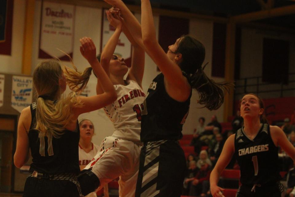 Several players converge in the paint as they look for the ball.