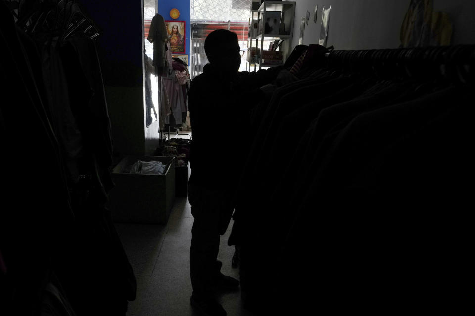 Un cliente compra ropa en una tienda sin electricidad debido a los cortes de energía programados por el Ministerio de Energía, en Quito, Ecuador, el martes 16 de abril de 2024. Ecuador enfrenta racionamientos de electricidad debido a una prolongada sequía y a las altas temperaturas que han reducido los caudales que abastecen a las principales centrales hidroeléctricas. (AP Foto/Dolores Ochoa)