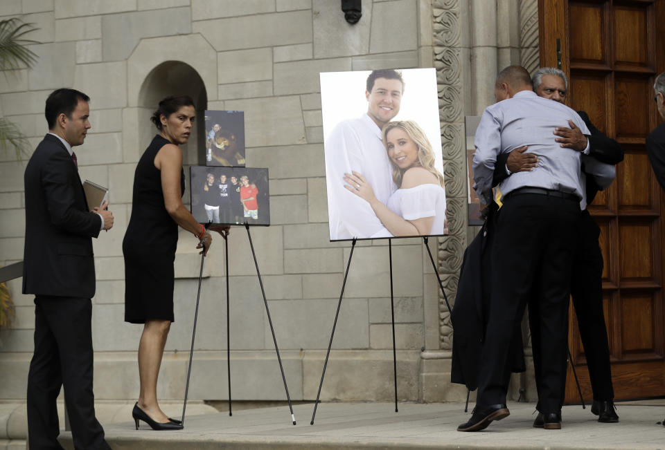 Debbie Hetman, left, mother of Los Angeles Angels pitcher Tyler Skaggs, stands in front of images of Skaggs during a memorial in his honor at the St. Monica Catholic Church Monday, July 22, 2019, in Los Angeles. (AP Photo/Marcio Jose Sanchez)