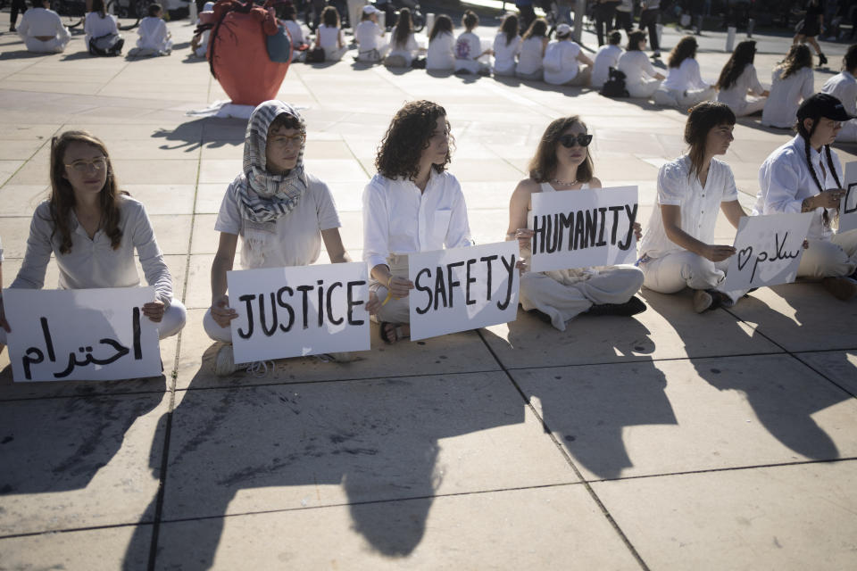 Women hold placards in Arabic, Hebrew, and English during a demonstration by Israeli and Palestinian women calling for peace, in Tel Aviv, Israel, Friday, Dec. 15, 2023. (AP Photo/Maya Alleruzzo)