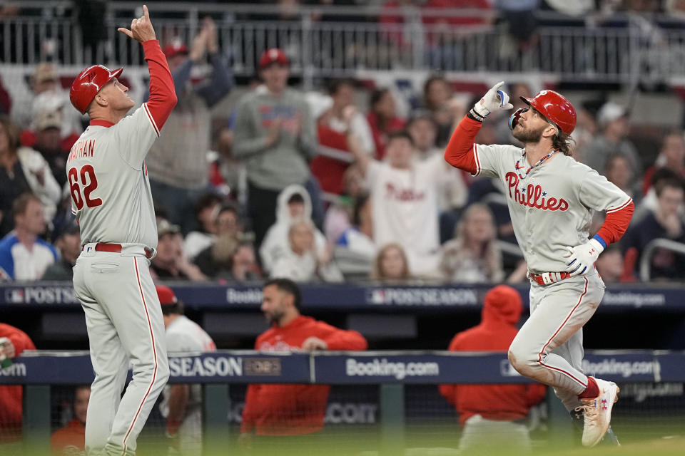 Philadelphia Phillies designated hitter Bryce Harper (3) celebrates his solo homer against the Atlanta Braves as third base coach Dusty Wathan (62) reacts during the sixth inning of Game 1 of a baseball NL Division Series, Saturday, Oct. 7, 2023, in Atlanta. (AP Photo/Brynn Anderson)