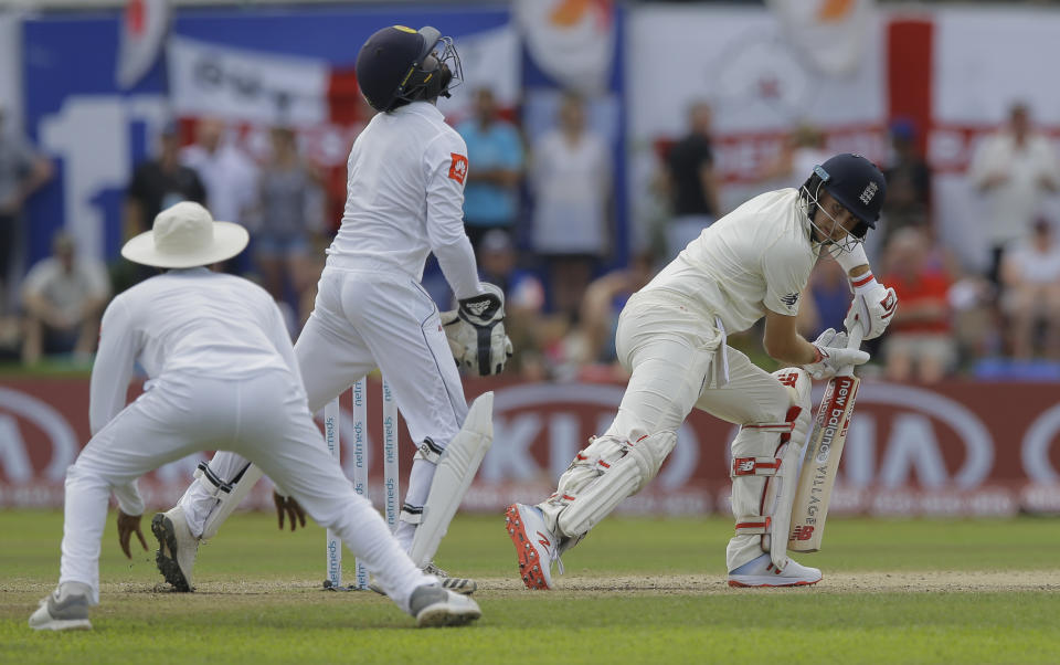 England's Joe Root, right, looks back as Sri Lanka's wicketkeeper Niroshan Dickwella, center, takes a catch to dismiss him during the third day of the first test cricket match between Sri Lanka and England in Galle, Sri Lanka, Thursday, Nov. 8, 2018. (AP Photo/Eranga Jayawardena)