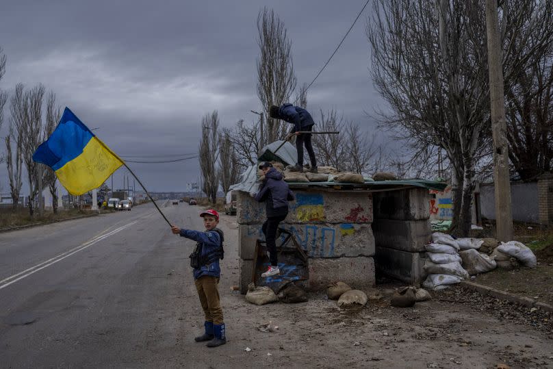 Ukrainian children play at an abandoned checkpoint in Kherson, November 2022