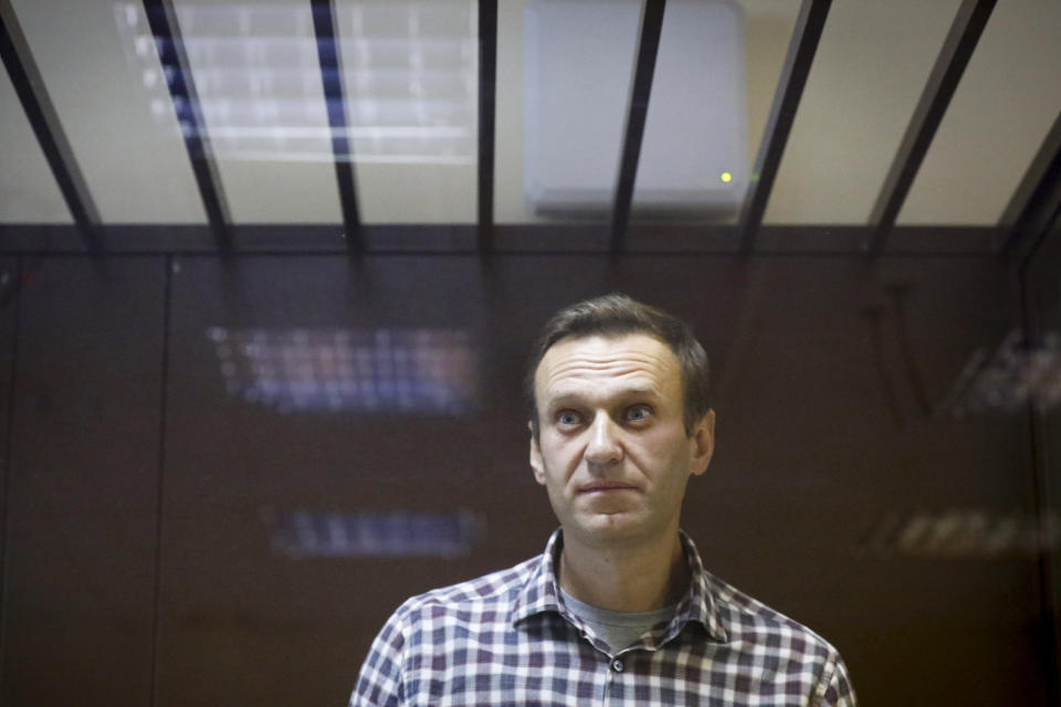 FILE - In this Saturday, Feb. 20, 2021 file photo, Russian opposition leader Alexei Navalny stands in a cage in the Babuskinsky District Court in Moscow, Russia. Alexei Navalny's lawyer Mikhailova said Navalny was taken to a hospital outside prison on Wednesday, March 24 for magnetic resonance tomography but wasn't given the results. She said Navalny has received pills and ointment for his pain, but prison authorities refused to accept medicines that lawyers brought to him. (AP Photo/Alexander Zemlianichenko, File)