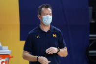 Michigan men's basketball athletic trainer Alex Wong watches from the sideline during the first half of an NCAA college basketball game Tuesday, Jan. 12, 2021, in Ann Arbor, Mich. College athletic trainers have busy lives, trying to keep up with student-athletes' injuries, rehab and making sure they get to doctor's appointments. The coronavirus pandemic has added another layer of work, from testing and contact tracing to keeping up with the latest protocols. (AP Photo/Carlos Osorio)