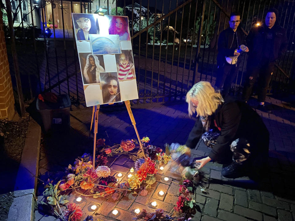 A resident places a flower on a memorial for Sasha Mason, a 45-year-old transgender woman killed in Zebulon, N.C., at a Transgender Day of Remembrance vigil in Raleigh, N.C., Sunday, Nov. 20, 2022. (AP Photo/Hannah Schoenbaum)