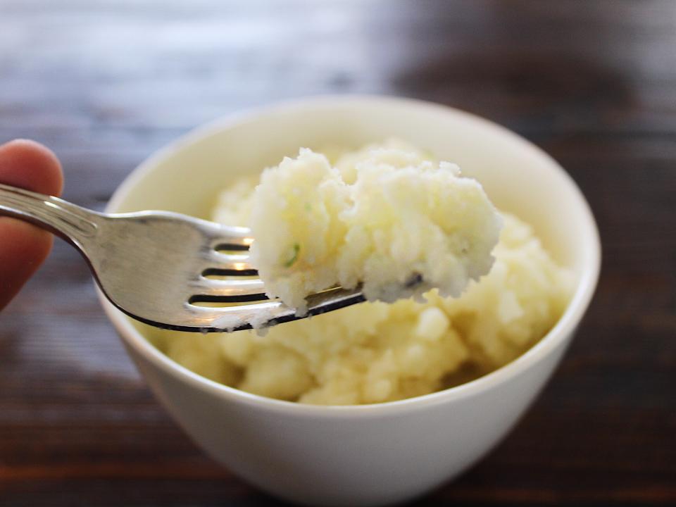 idahoan sour cream and chive mashed potatoes in a white bowl with fork