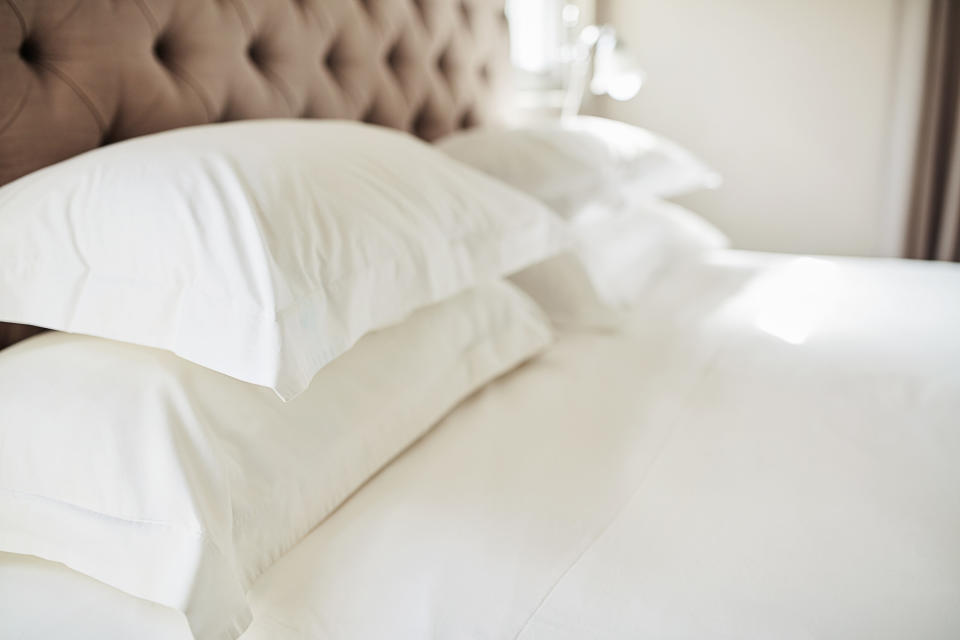 A bed with white pillows and sheets