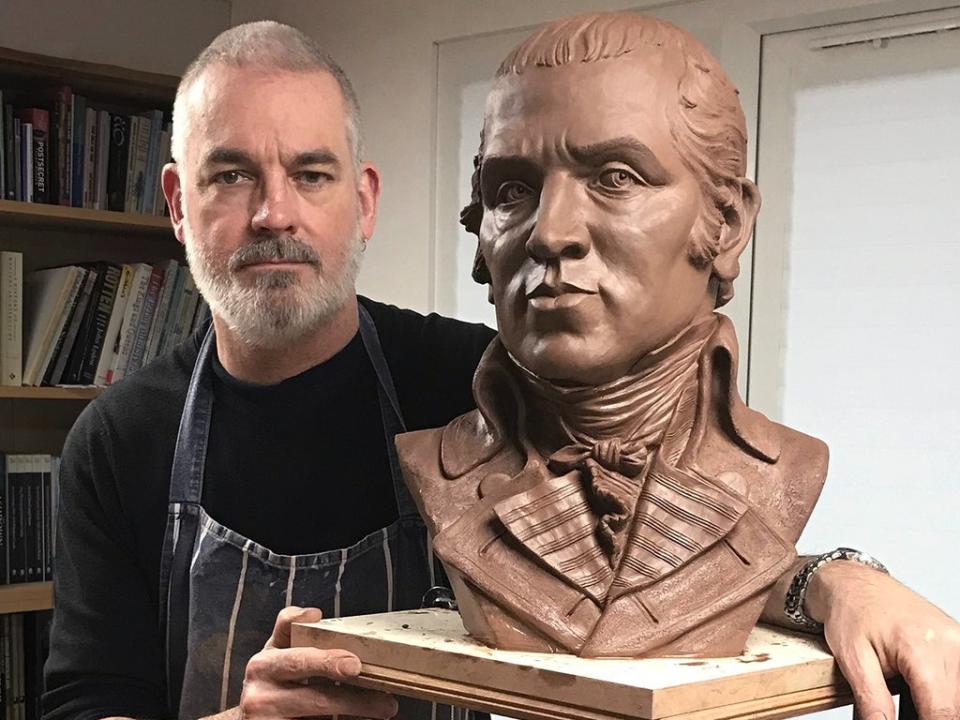 Dave Brown in his studio with the portrait of James Gillray in clay (© Kasia Kowalska 2021)