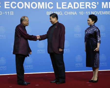 Philippine President Benigno Aquino (L) shakes hands with China's President Xi Jinping as Xi's wife Peng Liyuan stands beside, during the APEC Welcome Banquet at Beijing National Aquatics Center, or the Water Cube, in Beijing, November 10, 2014. REUTERS/Kim Kyung-Hoon