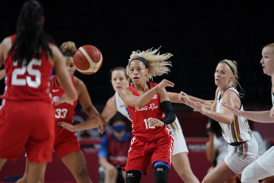 Puerto Rico's Dayshalee Salaman (12), center, passes to a teammate during women's basketball preliminary round game against Belgium at the 2020 Summer Olympics, Friday, July 30, 2021, in Saitama, Japan. (AP Photo/Charlie Neibergall)