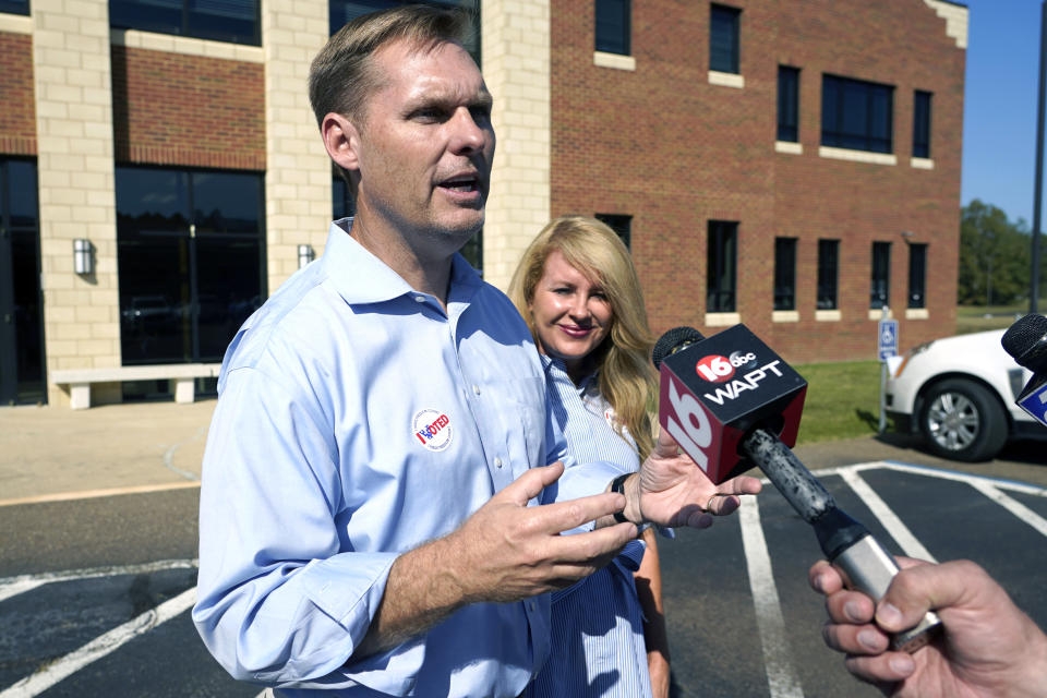 U.S. Rep. Michael Guest, R-Miss., answers reporters questions after he and his wife Haley Guest, right, cast their ballots at their Brandon precinct, Tuesday, Nov. 8, 2022, in Brandon, Miss. Guest, the incumbent, faces Democrat Shuwaski Young for the state's 3rd Congressional District seat. (AP Photo/Rogelio V. Solis)