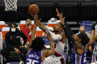 Portland Trail Blazers guard Damian Lillard, right, goes to the basket between Sacramento Kings' Marvin Bagley III, left, and Richaun Holmes, right, during the first quarter of an NBA basketball game in Sacramento, Calif., Wednesday, Jan. 13, 2021. (AP Photo/Rich Pedroncelli)