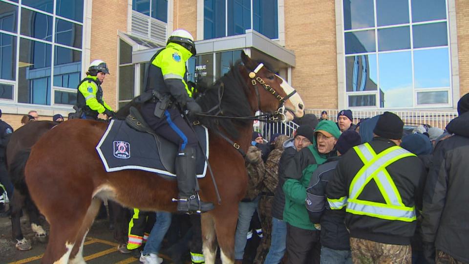 A police officer on horseback attempts to disperse a crowd outside Confederation Building in St. John's on Wednesday morning. 