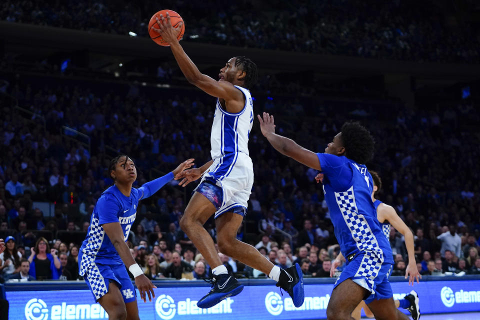 Duke's Jeremy Roach, center, drives past Kentucky's TyTy Washington, left, and Sahvir Wheeler, right, during the first half of an NCAA college basketball game Tuesday, Nov. 9, 2021, in New York. (AP Photo/Frank Franklin II)