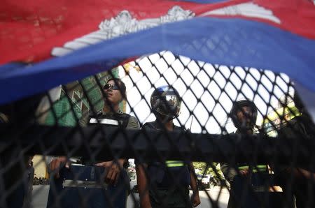 Police officers block a street as protesters demand the release of five opposition members of parliament, near the Phnom Penh Municipal Court in central Phnom Penh July 16, 2014. REUTERS/Samrang Pring