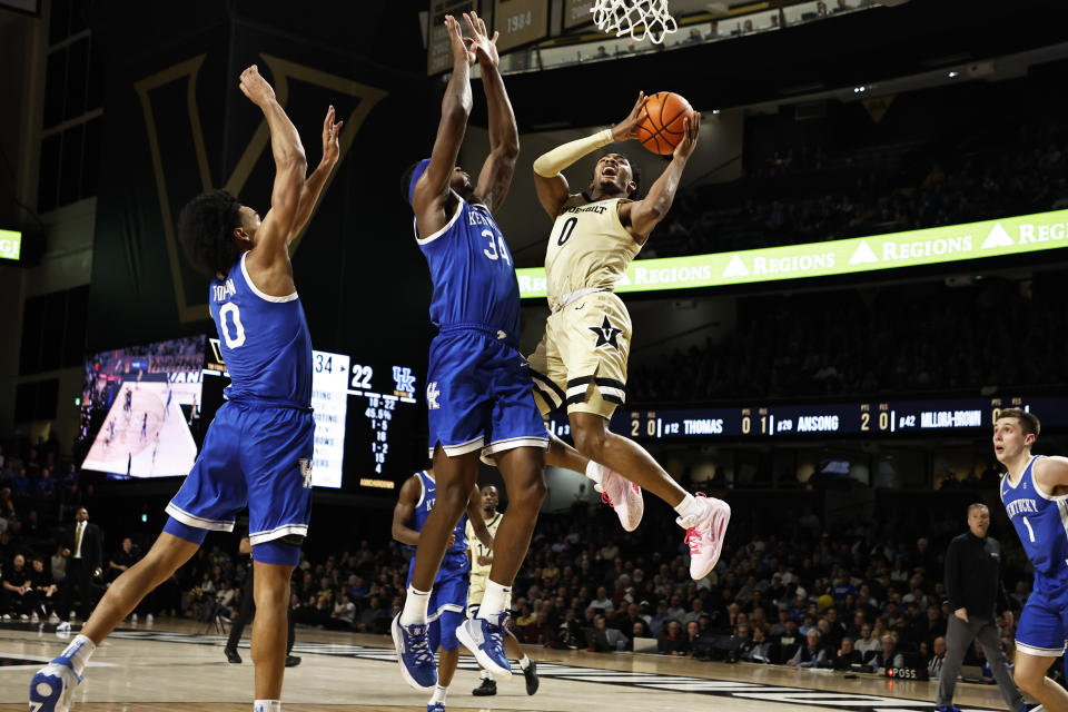 Vanderbilt guard Tyrin Lawrence (0) shoots as he's defended by Kentucky forward Oscar Tshiebwe (34) during the first half of an NCAA college basketball game Tuesday, Jan. 24, 2023, in Nashville, Tenn. (AP Photo/Wade Payne)