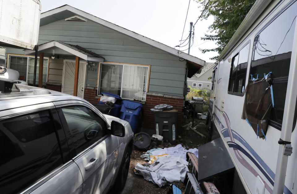 FILE - Vehicles are parked outside the home of Paige A. Thompson, who uses the online handle "Erratic," in Seattle. A federal jury on Friday, June 17, 2022, convicted the former Seattle tech worker of several charges related to a massive hack of Capital One bank and other companies in 2019. (AP Photo/Ted S. Warren, File)